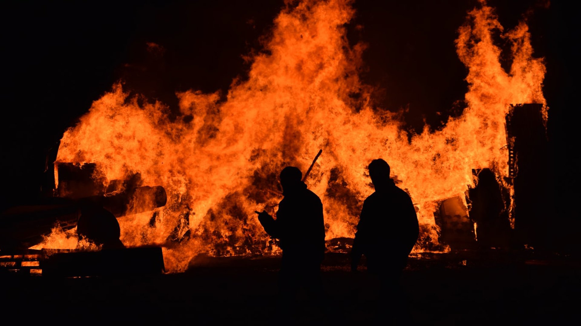 Too hot to handle-Two men in front of a raging fire.jpeg